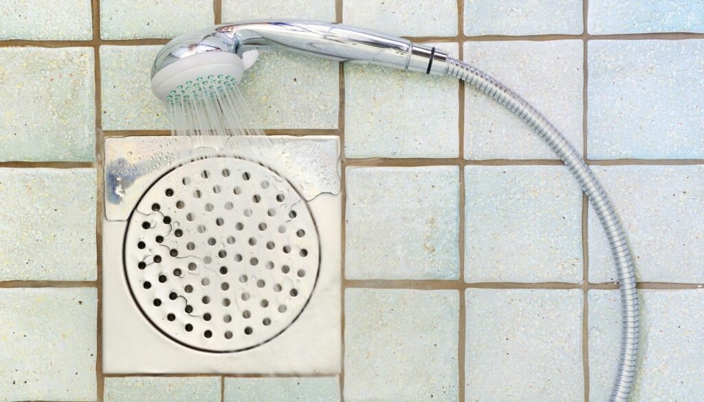 Shower drain with square small blocks tiles.